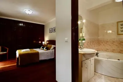 a bedroom with a bed and a tub and a sink at Villa Rose by AnaLodges in Senhora do Rosário