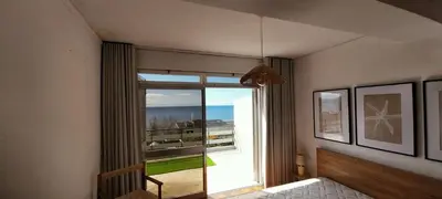 a room with a table and benches and a table and windows at Funchal Lido Duplex in Funchal
