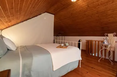 a bedroom with a large bed with a wooden ceiling at Portas da Levada A by Rent-a-key in São Vicente