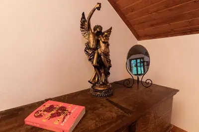 a statue of an angel sitting on a table next to a mirror at Portas da Levada A by Rent-a-key in São Vicente
