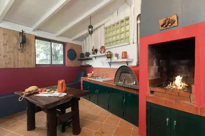 a kitchen with a table and a fireplace at Portas da Levada A by Rent-a-key in São Vicente