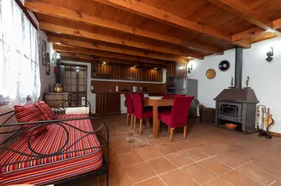 a kitchen and living room with a table and red chairs at Portas da Levada A by Rent-a-key in São Vicente