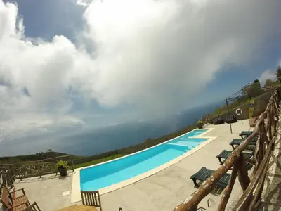 a table and chairs on a balcony with a view at Madeira Native Motion Apartment in Ponta do Pargo