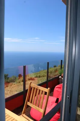 a living room with a black leather couch at Madeira Native Motion Apartment in Ponta do Pargo