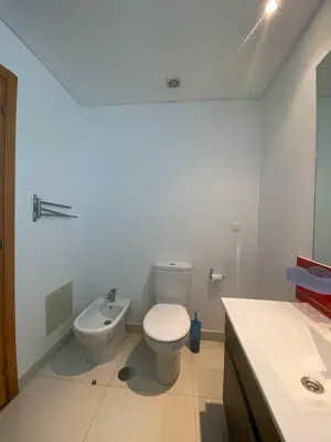 a white bathroom with a toilet and a sink at Amazing Views in Machico in Machico