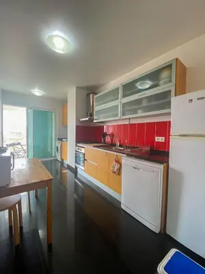 a kitchen with red cabinets and a white refrigerator at Amazing Views in Machico in Machico
