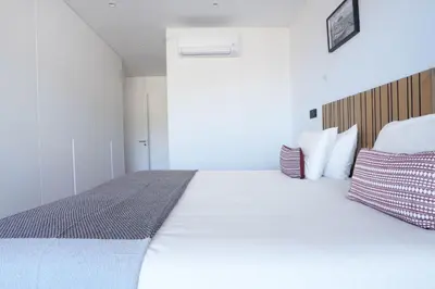 a bedroom with a large white bed with red and white pillows at Diamond Ocean View by LovelyStay in Funchal