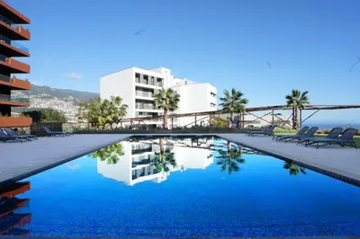 a swimming pool with blue water in front of a building at Diamond Ocean View by LovelyStay in Funchal