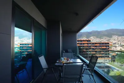 a room with a table and chairs on a balcony at Diamond Ocean View by LovelyStay in Funchal