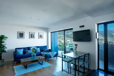 a living room with a blue couch and a table at Diamond Ocean View by LovelyStay in Funchal