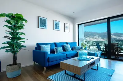 a living room with a blue couch and a table at Diamond Ocean View by LovelyStay in Funchal