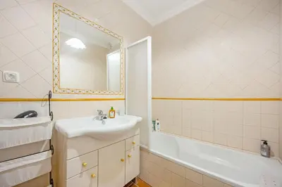 a bathroom with a sink and a tub and a mirror at Burgau - A Casa dos Avós in Burgau