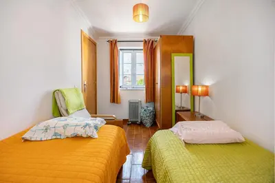 a bedroom with two beds and a mirror at Burgau - A Casa dos Avós in Burgau