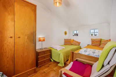 a bedroom with two beds and a cabinet at Burgau - A Casa dos Avós in Burgau