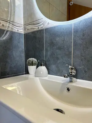 a bathroom sink with a mirror and a white sink at Maria apartment in Ponta do Sol