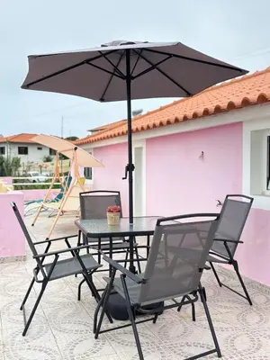 a table and chairs with an umbrella on a patio at Maria apartment in Ponta do Sol