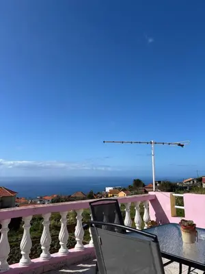 a table and chairs on a balcony with the ocean at Maria apartment in Ponta do Sol