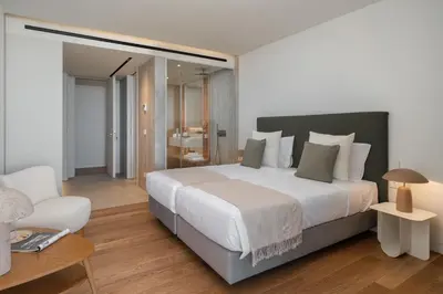 a bedroom with a large white bed and a chair at Luxury in Funchal - Savoy Monumentalis II in Funchal
