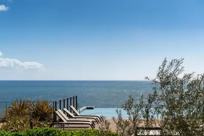 a group of chairs sitting next to the ocean at Luxury in Funchal - Savoy Monumentalis II in Funchal