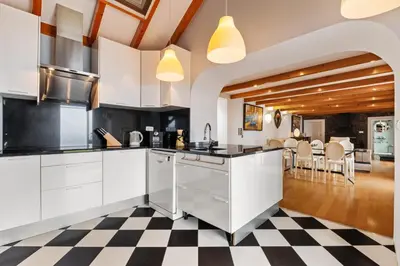 a kitchen with white cabinets and a checkered floor at Quinta da Fonte in Prazeres