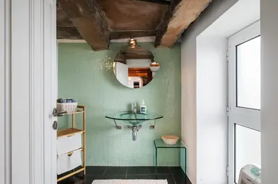 a bathroom with a glass table on a green wall at Quinta da Fonte in Prazeres