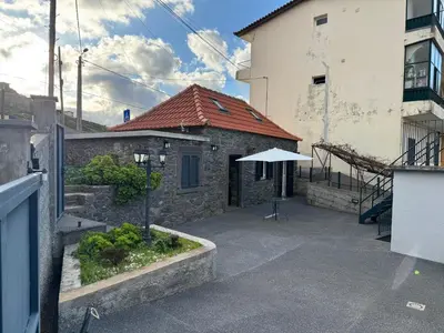 a building with a white umbrella in a courtyard at Jose CL in Estreito de Câmara de Lobos