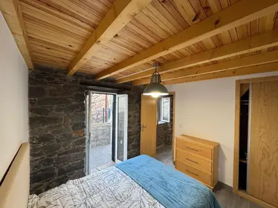 a bedroom with a bed and a stone wall at Jose CL in Estreito de Câmara de Lobos
