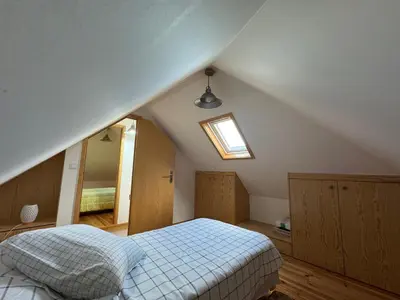 a attic bedroom with a bed and a window at Jose CL in Estreito de Câmara de Lobos