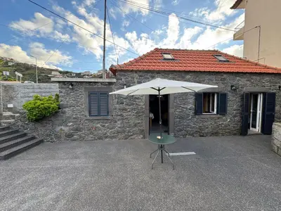 a white umbrella sitting in front of a building at Jose CL in Estreito de Câmara de Lobos