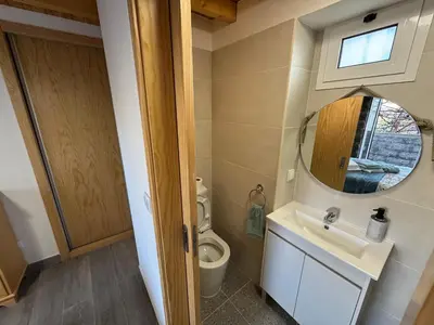 a bathroom with a toilet and a sink and a mirror at Jose CL in Estreito de Câmara de Lobos