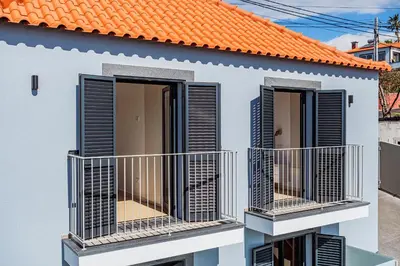 a white house with an orange roof and two balconies at Cocoon House in Canhas