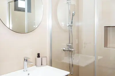 a bathroom with a shower and a sink and a mirror at Cocoon House in Canhas