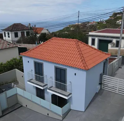 a small white house with an orange roof at Cocoon House in Canhas