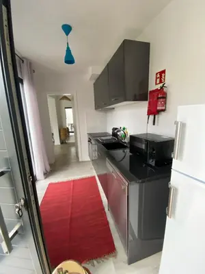 a kitchen with a black counter and a red rug at Holiday Apartments Funchal - Bouganvilla in Funchal