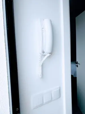 a white phone is hanging on a door at Holiday Apartments Funchal - Bouganvilla in Funchal