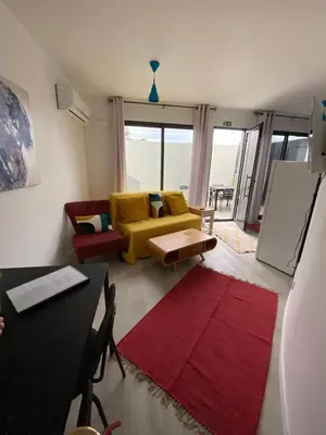 a living room with a yellow couch and a red rug at Holiday Apartments Funchal - Bouganvilla in Funchal