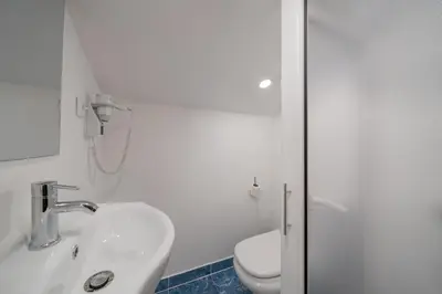 a white bathroom with a sink and a toilet at A refuge in nature - Chalet D'Avó Teresa in São Vicente