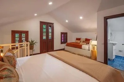 a large bedroom with a bed and a bathroom at A refuge in nature - Chalet D'Avó Teresa in São Vicente