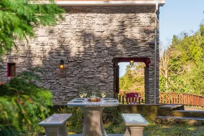 a stone building with a table with glasses on it at A refuge in nature - Chalet D'Avó Teresa in São Vicente