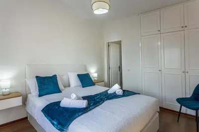 a bedroom with a large bed with blue pillows at Casa Barcelos View in Funchal