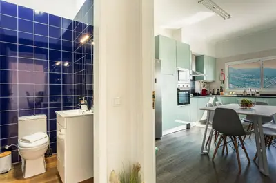 a bathroom with a toilet and a table with chairs at Casa Barcelos View in Funchal