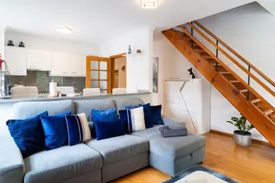 a living room with a couch and a staircase at GuestReady - Scenic Retreat with Stunning Views in São Vicente
