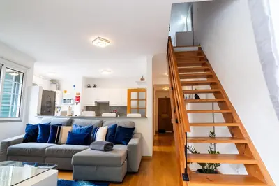 a living room with a couch and a staircase at GuestReady - Scenic Retreat with Stunning Views in São Vicente