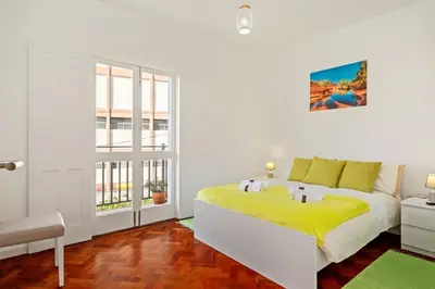 a white bedroom with a bed and a window at Quinta Paraiso in Funchal