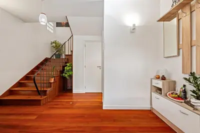 a hallway with a staircase and white walls and wood floors at Quinta Paraiso in Funchal