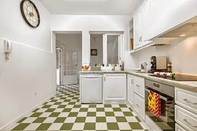 a kitchen with white cabinets and a checkered floor at Quinta Paraiso in Funchal
