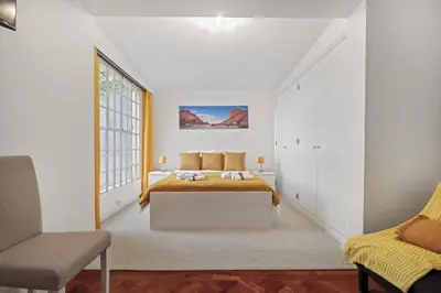a white bedroom with a bed and a window at Quinta Paraiso in Funchal