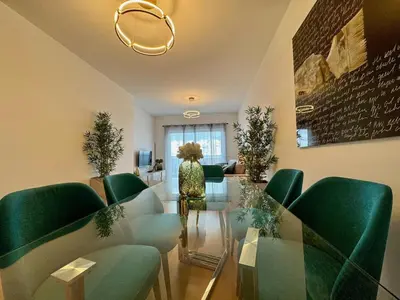 a woman in a room with green chairs and a glass table at Welcome to Paradise Island in Caniço