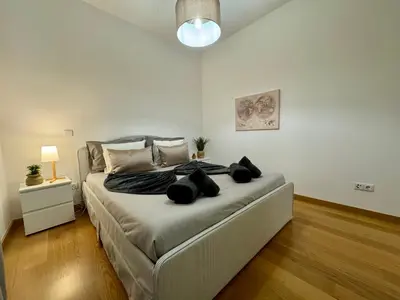 a bedroom with a large bed with black pillows at Welcome to Paradise Island in Caniço