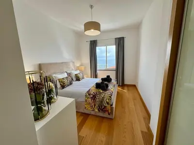 a bedroom with a bed with two cats sitting on it at Welcome to Paradise Island in Caniço